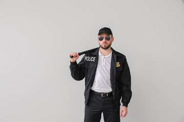 Male police officer on light background