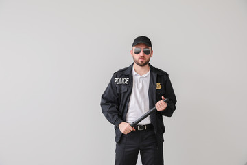 Male police officer on light background