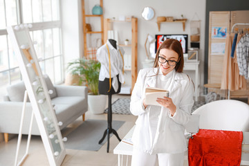 Obraz premium Young female tailor in atelier