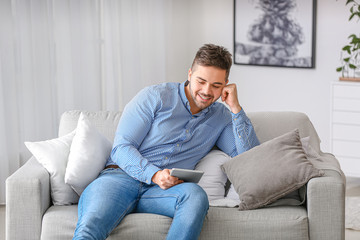 Handsome man with tablet computer at home