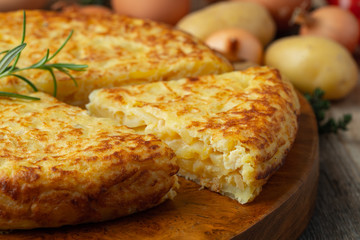 Spanish omelette with potatoes and onion, typical Spanish cuisine. Tortilla espanola. Rustic dark background - obrazy, fototapety, plakaty