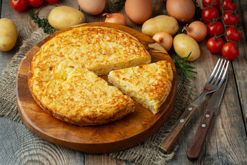 Spanish omelette with potatoes and onion, typical Spanish cuisine. Tortilla espanola. Rustic dark background