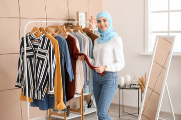 Portrait of female Muslim clothes stylist in office