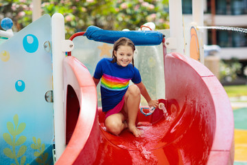 Kids on water slide in aqua park. Summer vacation