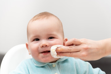 Mother Wipes Baby's Mouth With Napkin