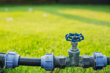 water valve pipe in the green garden grass field