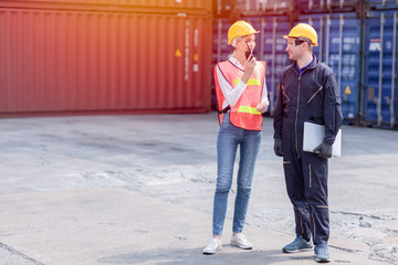 logistic worker man and woman working team with radio control loading containers at port cargo to...