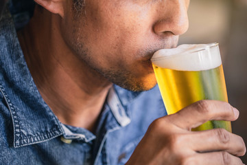 Happy friends drinking and toasting beer at brewery bar restaurant. Friendship concept with young people having fun together at cool vintage restaurant.