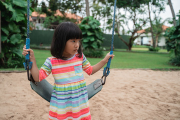 the girl will swing by herself on the playground