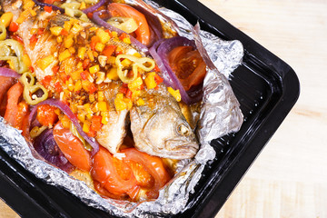 Grilled bass in a black baking tray