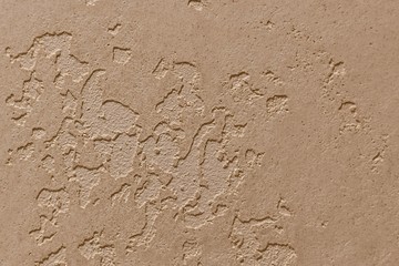 Beige light plaster background, with relief inflements.