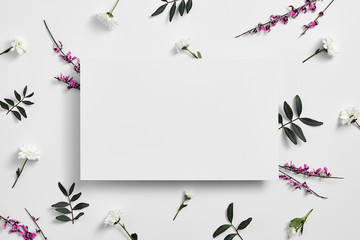 Spring minimal concept. Creative flowers flat lay. White paper blank. Top view
