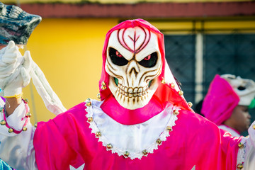 closeup man in scary mask and costume poses for photo on dominican city street