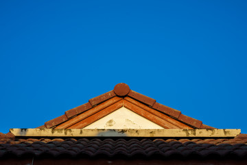 The roof of the orange house against the blue sky
