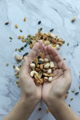 top view of mixed nut on women hand 
