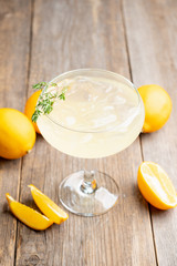 Tasty and little bitter lemon cocktail with slice of fresh lemon and thyme. Selective focus. Shallow depth of field.