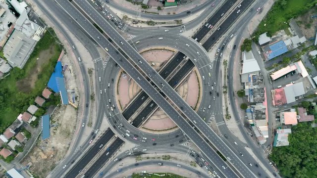 Hyperlapse timelapse zoom out of day city traffic on 4-way stop street intersection circle roundabout in bangkok, thailand. 4K UHD horizontal aerial view.