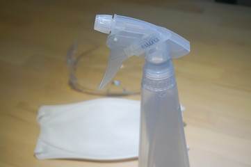 Virus protection equipment sensitizer sprayer respiratory mask and glasses on the table