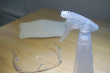 Virus protection equipment sensitizer sprayer respiratory mask and glasses on the table