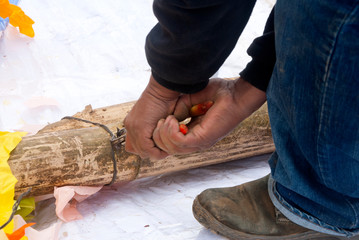 Hands of brunette latin man, working with tongs, cutting wire, outdoor work, craft crafting giant kite in Guatemala.