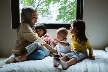 mother storytelling to her daughter on the bed play together