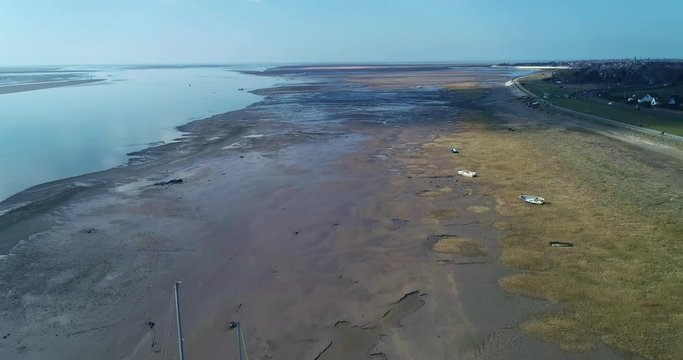 Drone flight along Lytham shore.The camera tilts to reveal the river estuary leading to the sea, showing the full width of the shoreline. The management of the mud flats slows down coastal erosion.