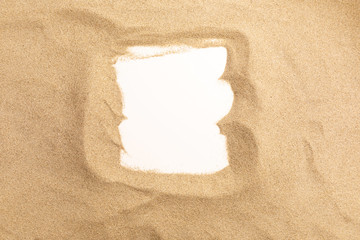 Sand on white background. Summer background with copy space and frame for text. Top view.