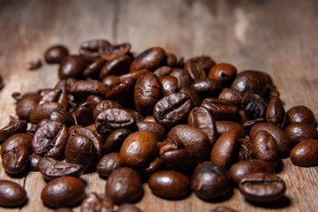 Fragrant roasted coffee beans and smoke on the old wooden.