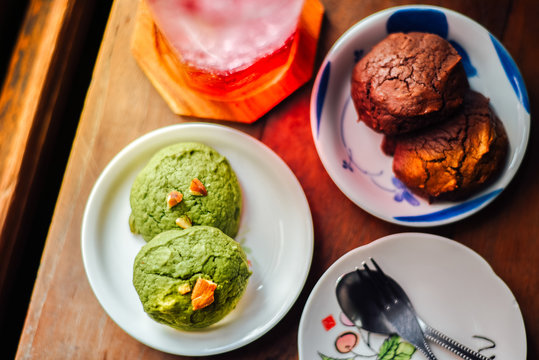 White Chocolate Matcha And Chocolate Brownie  Brownies Cookies  In Plate And Iced Red Soda On Wood Table.