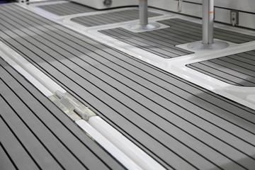Luxury motor yacht cockpit grey marine teak floor deck interior design close up