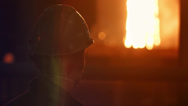 Young Man Working in a steel mill working in the hot manufacture