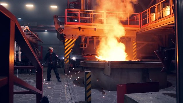 Man Working in a steel mill working in the hot manufacture