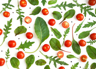 Creative flat layout of cherry tomatoes, lettuce, chard, mizuna, top view. Vegetables isolated on a white background.