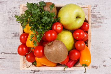 Fruits with vegetables in wooden box as healthy snack or dessert containing natural vitamins