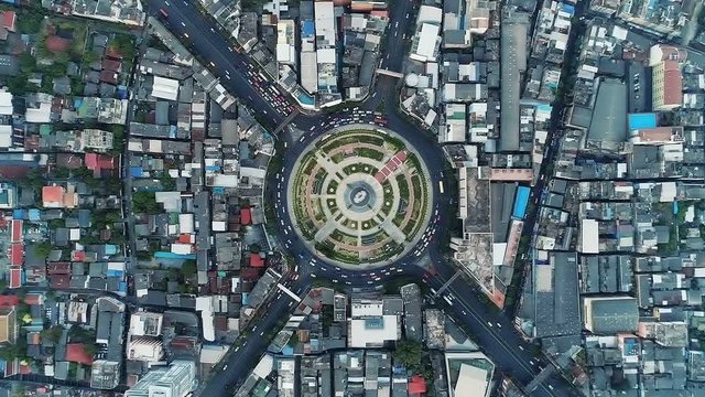 Hyperlapse timelapse moving go right circular of night city traffic on 4-way stop street intersection circle roundabout in bangkok, 4K UHD horizontal aerial view.