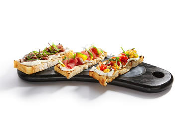 Bruschetta with baked pepper, tuna, avocado and pastrami