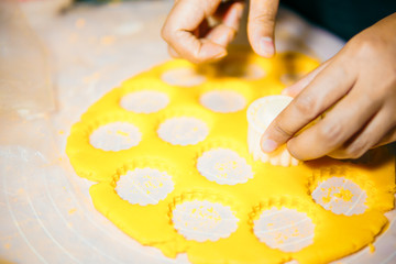 Close up of female hands making cookies from fresh dough at home