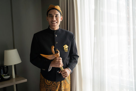 Asian man wearing traditional clothes,beskap and keris is traditional heritage clothes from Java,Indonesia