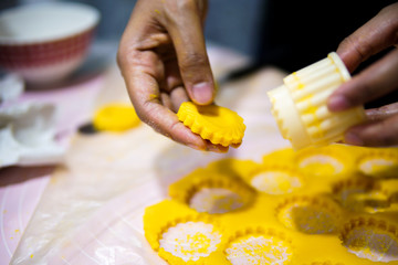 Close up of female hands making cookies from fresh dough at home