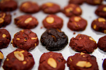 Burnt cookies in the middle of red velvet cookies on a tray