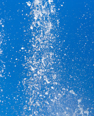 Splashing water from a fountain on a background of blue sky
