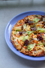 Crispy vegetable pizza served in a plate and photographed in half.