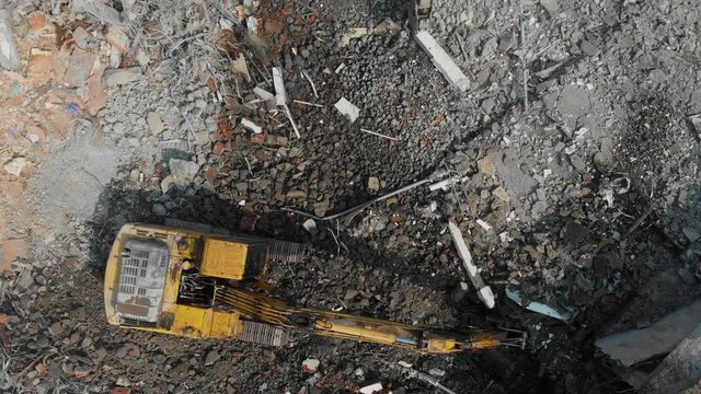 Aerial overhead moving forward view of a demolition site with two excavators