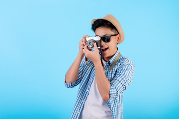 Cute amateur Asian photographer smiling and taking pictures on a blue background.