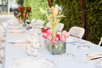 table holiday serving decoration on a patio easter idea with flower bouquet easter eggs rabbit with blue table cloth