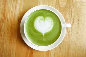 A cup of green tea matcha latte on wooden background                                                              