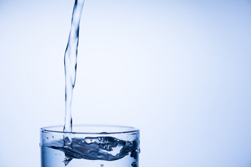 Cropped close up photo of top of glass of fresh pure clean water isolated over light pastel blue background with place for text empty blank space