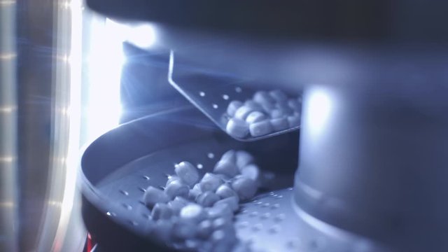 Process of production of pills, tablets. Industrial pharmaceutical concept. Factory equipment and machine. Many pills move on the machine. Medical capsules are sorted by a conveyor belt
