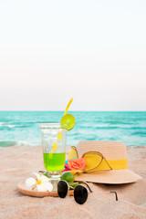 Lemon italian soda with beach accessories on beach.