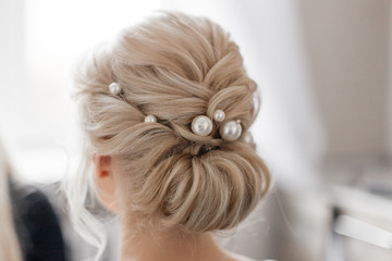  female gentle hairstyle on blond hair with pearl hairpins